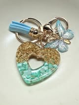 Resin filled heart shaped pendant with all gold hardware, an adorable little tassel and finally a stunning butterfly